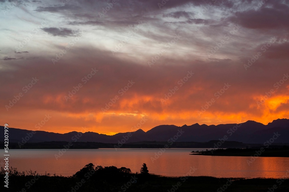 Beautiful shot of a sunset over a lake and mountains