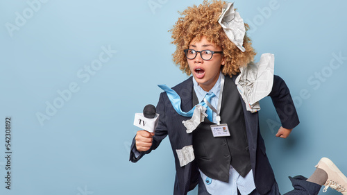 Photography Professional reporter looks amazed on left going to present news to audience has excellent interview skills meets deadline for preparing reportage runs somewhere with microphone in hand
