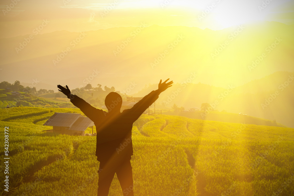 Man raising his arms in the middle of nature