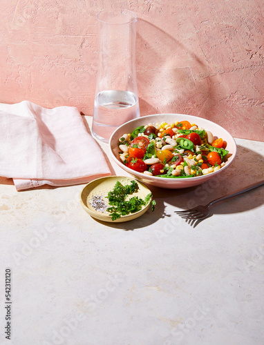 Vegetables and beans in bowl with herbs