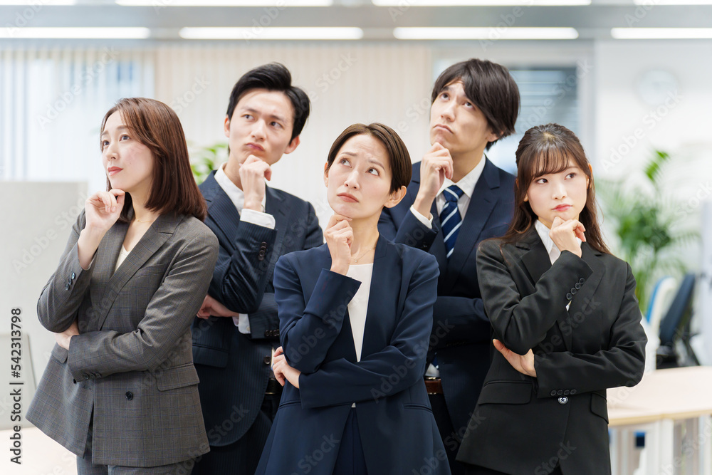 オフィスで考え事をするビジネスパーソン オフィスで考え事をするビジネスパーソン