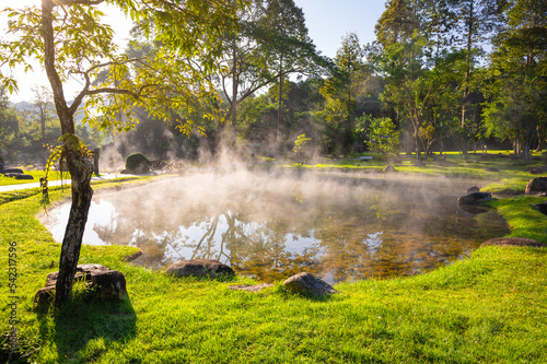 Natural hot spring with steam, rock and reflection in the morning at Chae Son National Park, Lampang, Thailand. photo