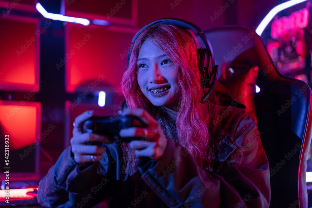 You win. Gamer using joystick controller plays online video game with computer neon lights backgrounds, woman use gaming headphones playing live stream esports games console at home. You win. Gamer using joystick controller plays online video game with computer neon lights backgrounds, woman use gaming headphones playing live stream esports games console at home.