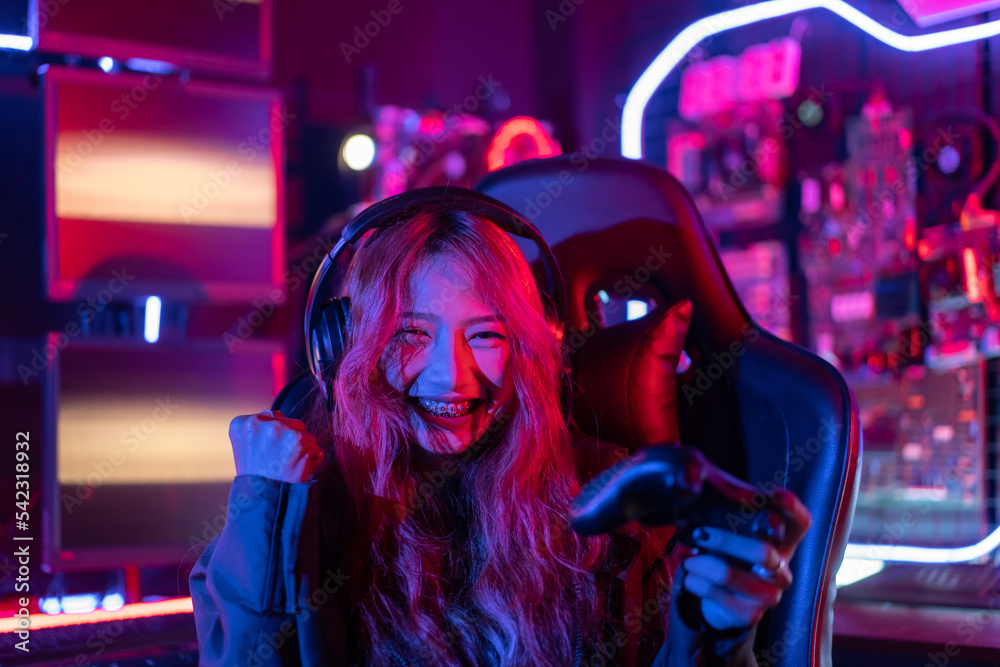 You win. Gamer using joystick controller plays online video game with computer neon lights backgrounds, woman use gaming headphones playing live stream esports games console at home. You win. Gamer using joystick controller plays online video game with computer neon lights backgrounds, woman use gaming headphones playing live stream esports games console at home.