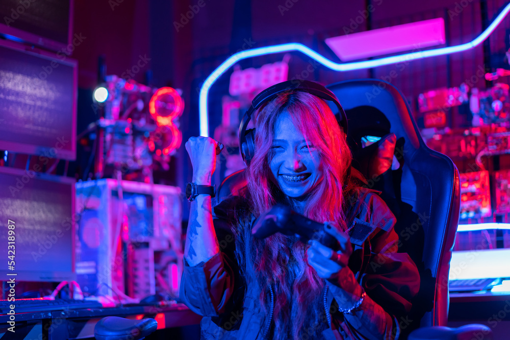 You win. Gamer using joystick controller plays online video game with computer neon lights backgrounds, woman use gaming headphones playing live stream esports games console at home. You win. Gamer using joystick controller plays online video game with computer neon lights backgrounds, woman use gaming headphones playing live stream esports games console at home.