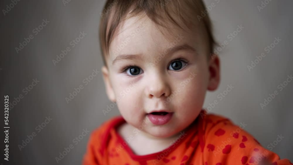 Beautiful lovely baby with grey eyes looks at camera. Portrait of a Caucasian child pointing at camera with a finger. Close up. Beautiful lovely baby with grey eyes looks at camera. Portrait of a Caucasian child pointing at camera with a finger. Close up.