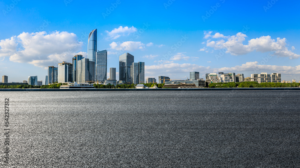 Asphalt road and city skyline with modern building in Suzhou, China.