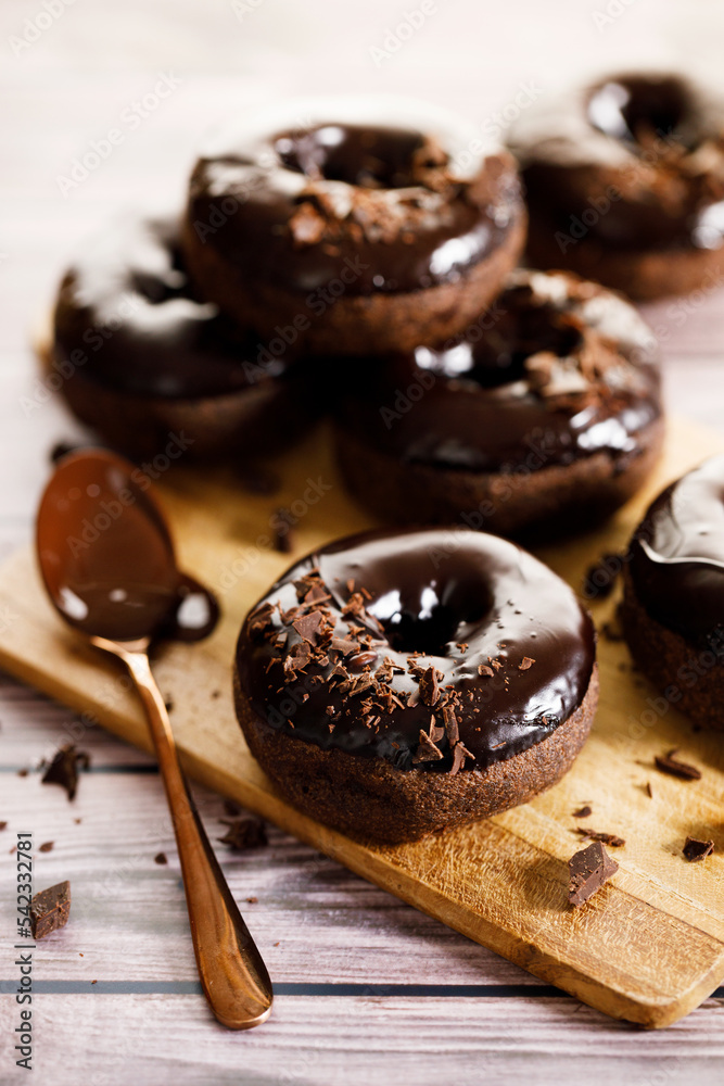 Chocolate donuts on wooden table background.