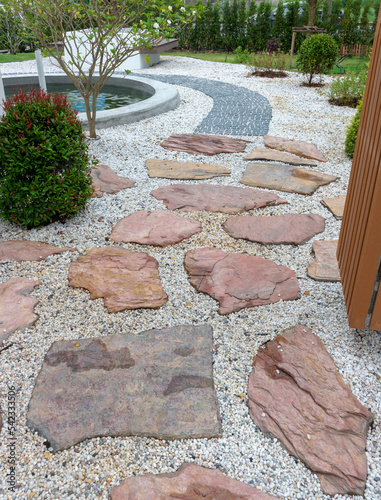 Stone slab walkway laid on gravel in an English garden style.