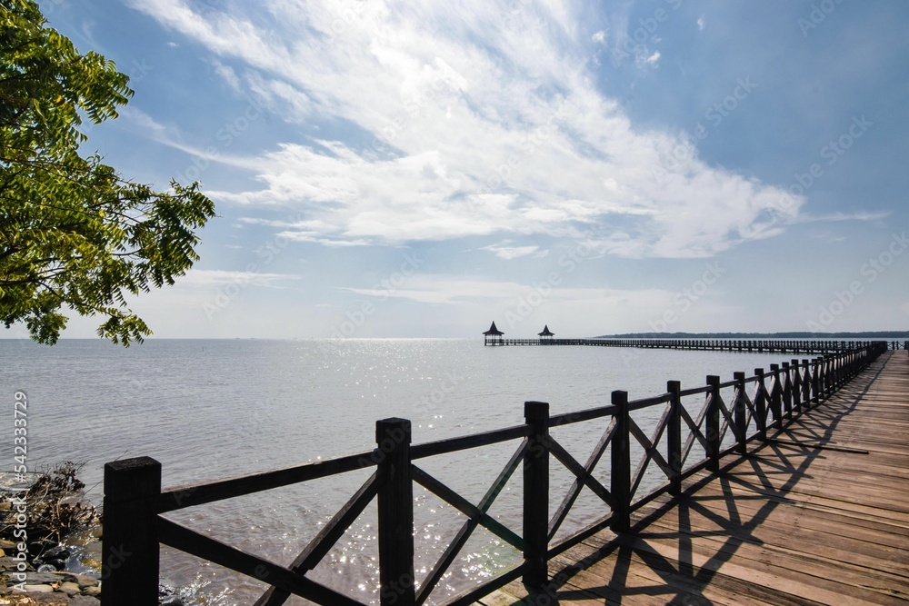 Old wooden pier in front of the see with a beautiful cloudy sky in the background Old wooden pier in front of the see with a beautiful cloudy sky in the background