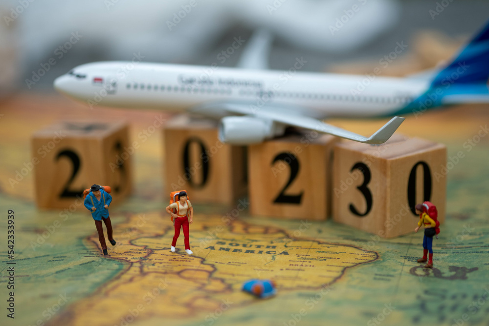 Miniature People tourist walking on the map as background travelling or business 2023 , travel,background
