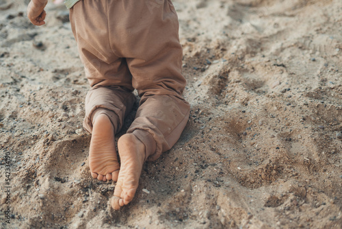 Obraz na plátně Boy's legs playing in sand on a sunny morning