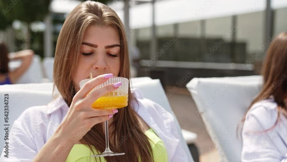 Female tourist enjoying cocktails in the poolside. Pretty beautiful ladies in swimsuit relaxing on the beach. Female tourist enjoying cocktails in the poolside. Pretty beautiful ladies in swimsuit relaxing on the beach.