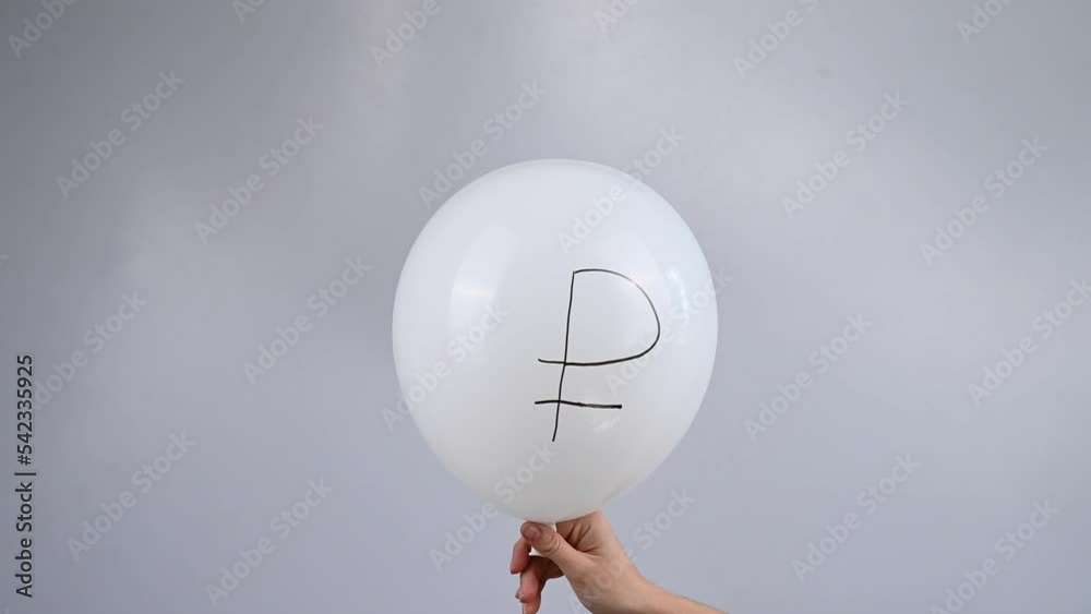 A woman is holding a deflating white balloon with the euro symbol.