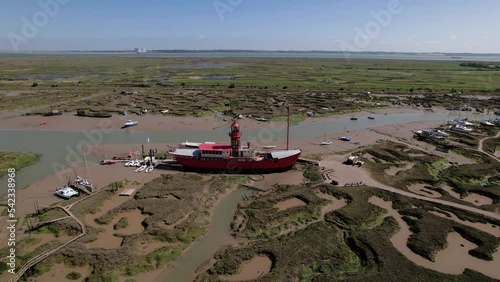 Aerial view away from a stranded LV15 Trinity Lightvessel, sunny Tollesbury, UK - pull back, drone shot photo