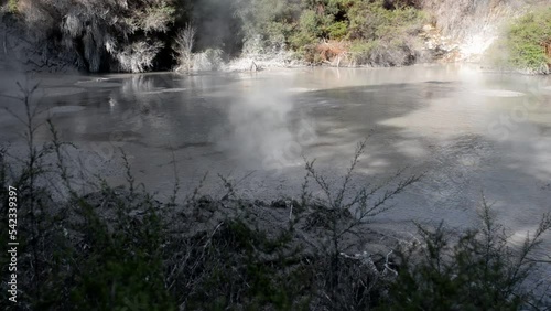 Small bubbles and steam rising from the Waiotapu hot mud pools during golden hour. Handheld close-up shot photo