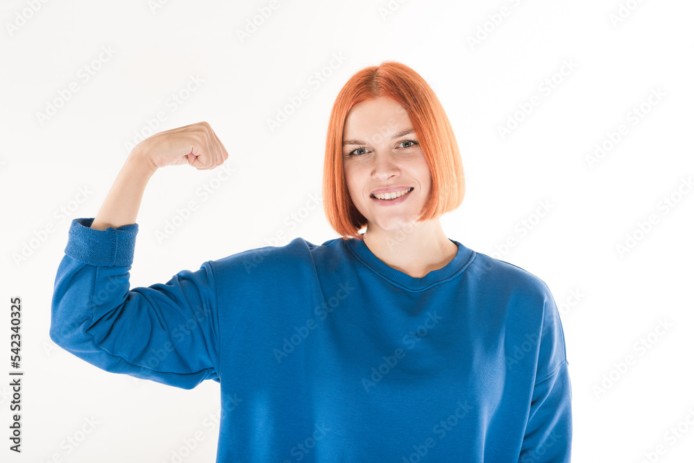 Fototapeta premium The girl shows biceps muscles on her arm on a white background.