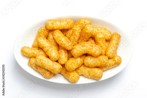 Peanut flips, in a white bowl. Also known as Bamba, peanut puffs or snips, is a puffed, peanut-flavored corn snack, with a peanut content up to a third. Close-up, from above, macro food photo.