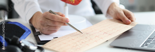 Papier peint Doctor cardiologist examines electrocardiogram of patient heart in cardiology