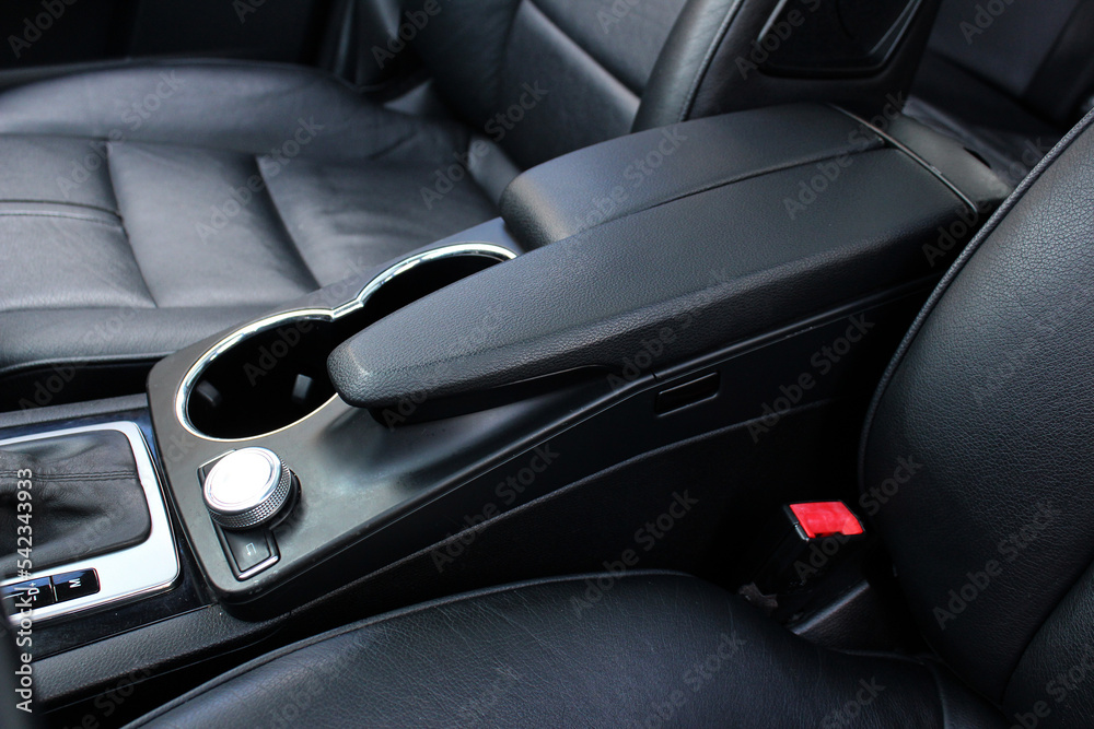 Armrest in the car for driver. Car armrest with cup holder. Armrest in the luxury passenger car between the front seats. 