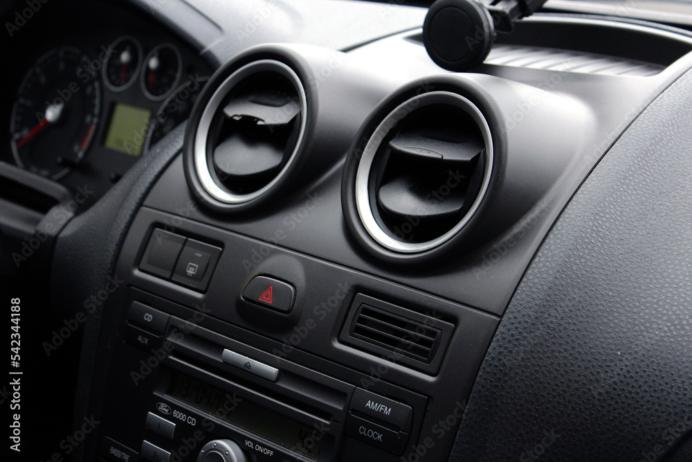 Close up car ventilation system and air conditioning - details and controls of modern car. Close-Up Of Air Vent In Car. Red emergency button on a dashboard of car.