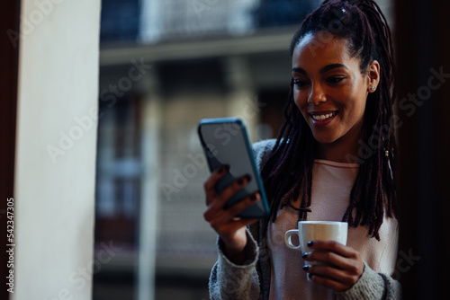 Woman texting on mobile phone at home.