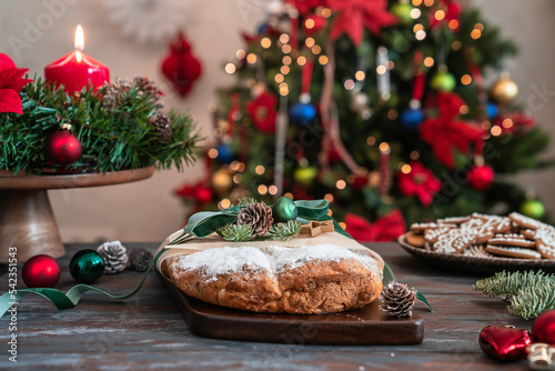 Homemade Christmas stollen on wooden table with winter holidays decoration. Traditional Christmas pastry dessert – Stollen. Xmas greeting card. 