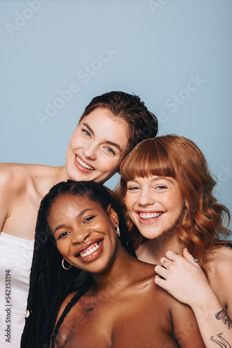Canvas Print Happy women with different skin tones smiling at the camera in a studio