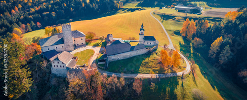 Colorful autumn view from flying drone of Kapelle (Cappella di castel Lamberto) castel. Aerial evening scene of italian countryside. Traveling concept background.