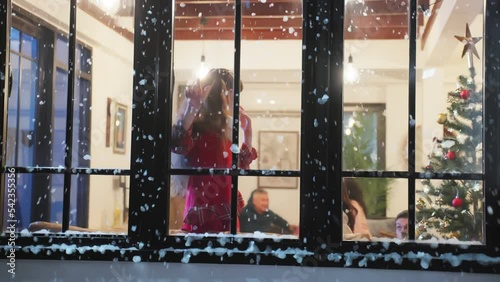 Adorable child look through the window and admiring first snow flakes.  photo