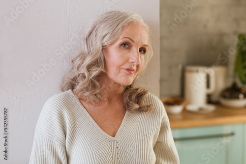 portrait of an elderly woman with gray hair looking into the camera at home