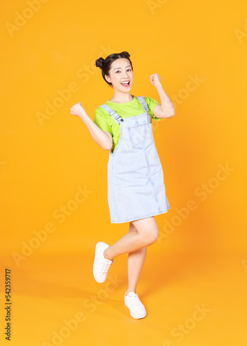 Full length image of young Asian woman standing on background © Timeimage