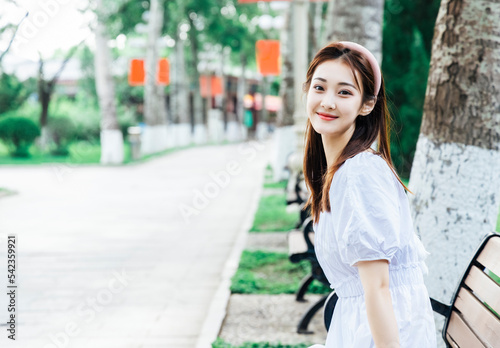 An Asian girl in a white dress playing in the park