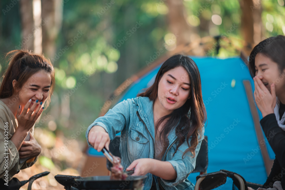 Obraz premium Young women cooking and use smartphone take photo on camping