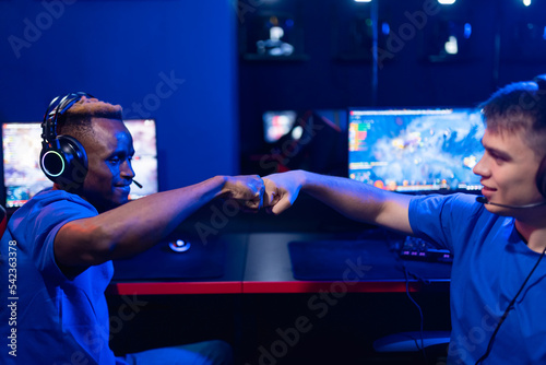 Fotografia Two man professional cyber sport gamers giving fist hand bump