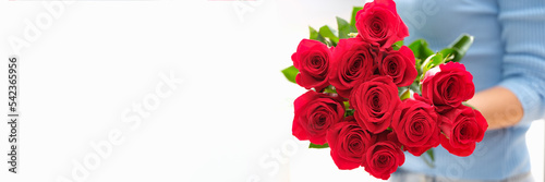 Woman is holding bouquet of beautiful red roses