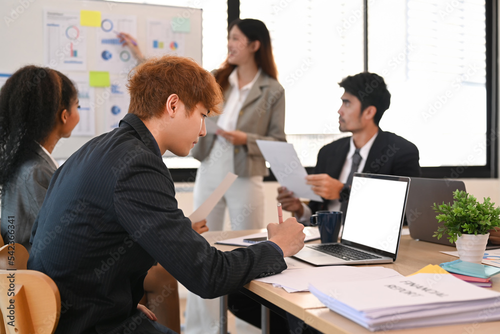Image of young businesspeople collaborating on new startup project together at modern corporate office Image of young businesspeople collaborating on new startup project together at modern corporate office