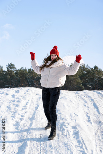 Portrait of young girl in winter outdoors has fun. ertical frame photo