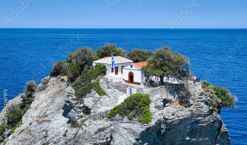 Closeup view of the little church of Agios Ioannis, high up on a steep cliff over the Aegean Sea and famous from the movie Mamma Mia at Skopelos island, Greece photo