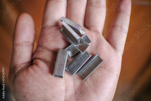 Sharp metal stapler refill on a wooden background
