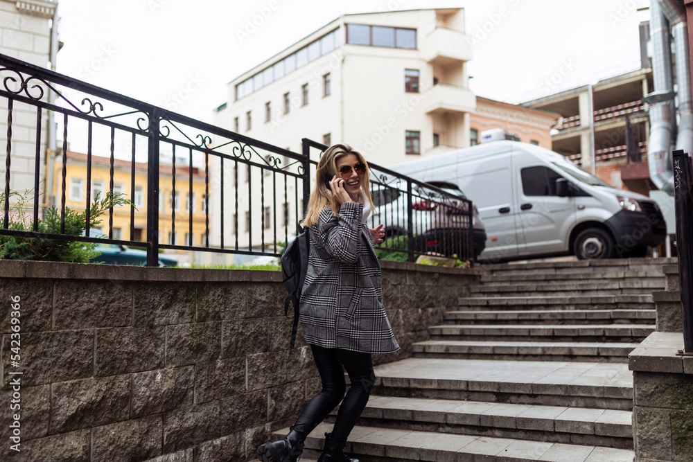 a woman climbs the stairs speaks on a mobile phone and turns around