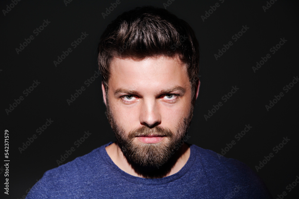 Portrait of bearded young man in front of black background Portrait of bearded young man in front of black background