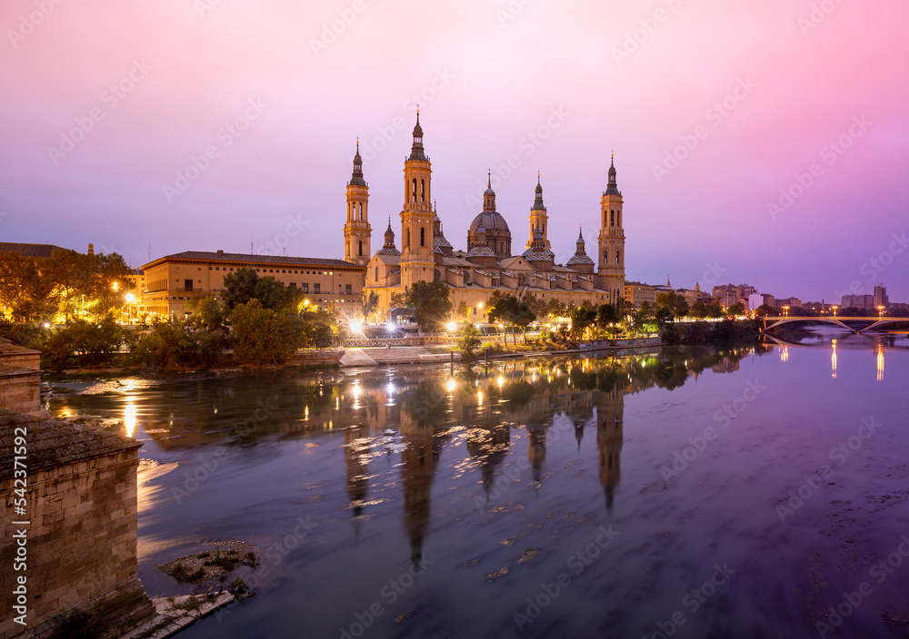 Scenic landscape with the Basilica of El Pilar in Zaragoza at sunrise reflected in the Ebro river