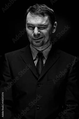 Man in full suit winking eyes, close up