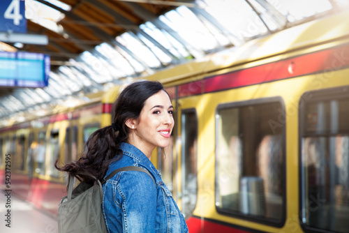 Germany, Berlin, young woman waiting in front of city train