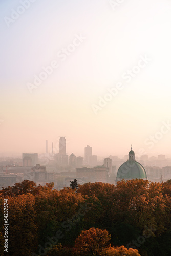View from Cidneo Hill top to silhouette of skyscrapers in business part of Brescia and dome of New Cathedral in the autumn fog, Lombardy, Italy photo