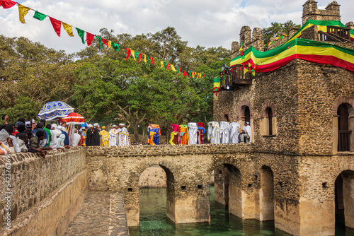 GONDAR, ETHIOPIA - JANUARY 18, 2019: Ethiopian orthodox priests leaving the bath house of Fasilides Bath while carrying the tabot.