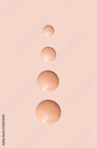 cosmetic smear round drops of foundation on beige background