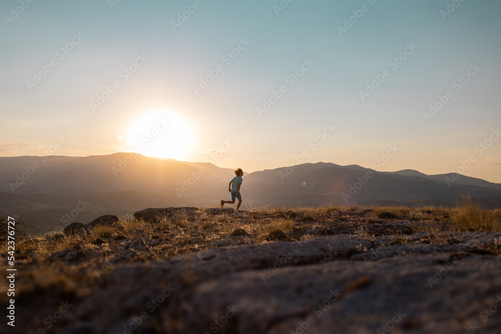 silhouette of a running man against the background of the sky and sunset in the mountains, sports and recreation.
