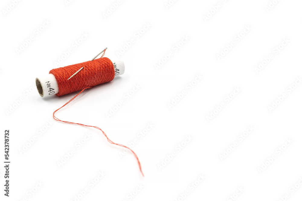 Spool of red thread with a needle isolated on white background. Red ...